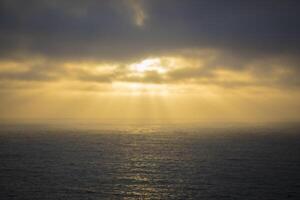 Golden Sunset Rays Over Calm Seascape photo