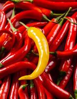 Eye-catching Yellow Chili Among Red Chilies Contrast Background photo