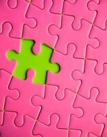 Vibrant Pink Jigsaw Piece on a Green Backdrop Striking Contrast photo