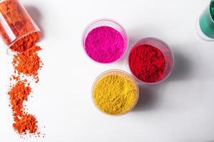 Colorful holi powder in glass jars on white background photo
