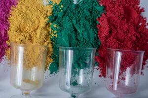 Colorful holi powder with empty glass vase on white background. photo