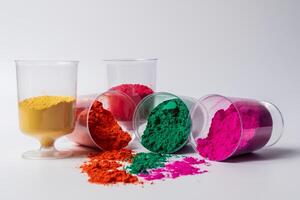 Colorful holi powder in a glass container isolated on white background. photo