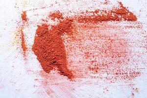 Red holi powder scattered on white background. Concept of Holi festival of colors. Top view photo