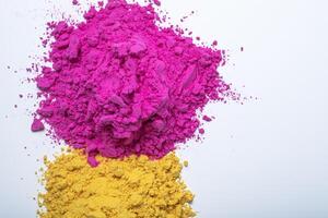 Pile of yellow and pink color holi powder isolated on white background. photo