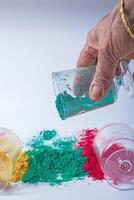 Close up shot of hand mixing colored holi powder for Holi festival. photo