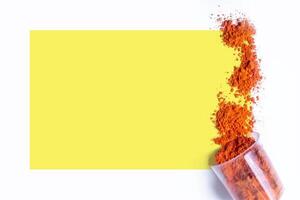 Red holi powder with yellow frame on white background. Holi Greeting Card photo