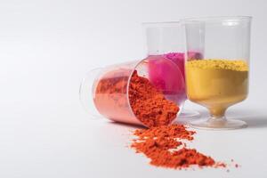 Colorful holi powder in measuring cups on a white background photo