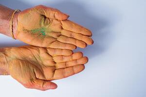 Close-up of human hand with holi powder in hand isolated on white background. photo