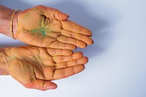 Close-up of human hand with holi powder in hand isolated on white background. photo