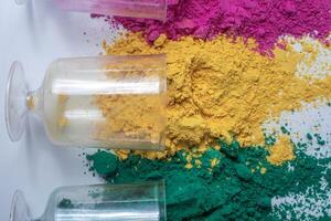 Multicolored holi powder in glass jars on white background. photo