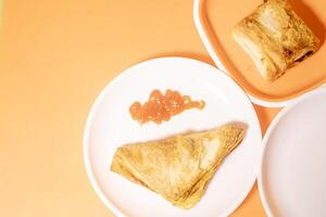 Vegetable puff with ketchup on plate on orange background. photo