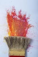 Paint brushes with colorful holi powder on white background photo