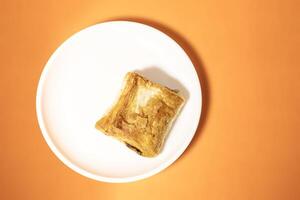 Veg puff on white plate on orange background photo