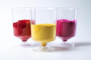 Multicolored holi powder in a glass isolated on white background. photo