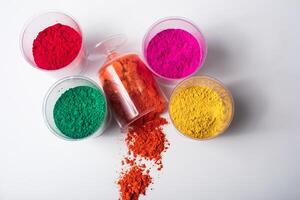 Colorful holi powder in plastic containers isolated on white background. photo