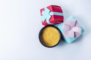 Gift box and holi powder on white background with copy space for text. photo