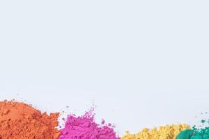 Pile of multicolored holi powder isolated on white background photo