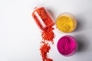 Colorful holi powder in a glass container on a white background photo