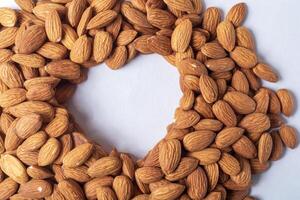 Almond nuts in heart shape on white background. Healthy food concept. photo
