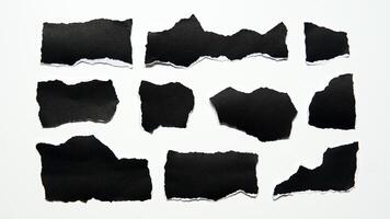 Torn black paper sheet isolated on white background photo