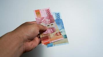 Men's hands showing Indonesian rupiah currency photo