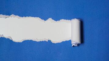 Torn blue paper sheet isolated on white background photo