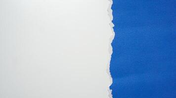 Torn blue paper sheet isolated on white background photo