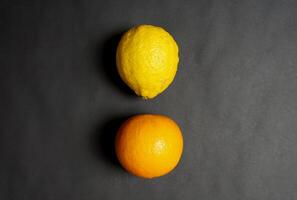 Lemon and oranges on black background photo