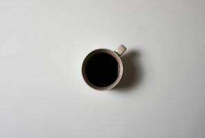 un taza de negro café en un blanco antecedentes. foto