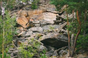 Stone rocks. Large stones in a coniferous forest. Granite quarry. Abandoned industrial production. photo