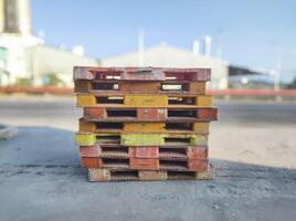 selective focus to pile of old and dirty empty pallets with blur factory background. concept of company going out of business photo