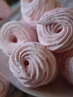 Pink homemade sweet marshmallow zephyr dessert on a white plate photo