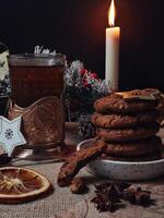 Christmas time served table with hot drink and chocolate cookies with candles and pine tree photo