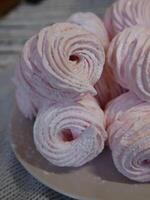 Pink homemade sweet marshmallow zephyr dessert on a white plate photo