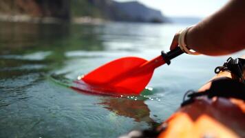 Kayak paddle sea vacation. Person paddles with orange paddle oar on kayak in sea. Leisure active lifestyle recreation activity rest tourism travel video
