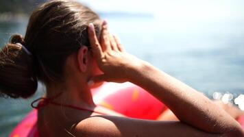 mujer flotadores en un inflable rosquilla colchón. contento mujer relajante y disfrutando familia verano viaje Días festivos viaje en el mar. video