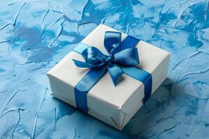 White gift box with a bow, on a blue background photo