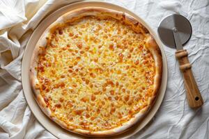 Baked pizza on a plate, pizza cutter, top view photo