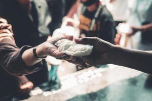 Volunteers handing delicious food to the homeless poor . concept of hunger problem photo