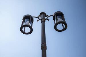 Lamps mounted to outdoor poles on blue background. photo