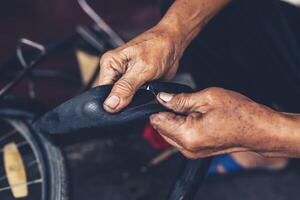 The mechanic patched the inner tube of the bicycle with glue and patch. photo