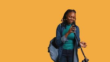 African american motivational speaker talking in microphone, addressing audience, holding speech, studio background. Inspiring woman using mic to present life lectures, camera B video