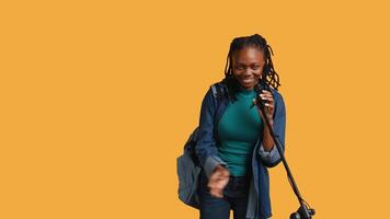 Portrait of african american motivational speaker talking in microphone, addressing audience, isolated over studio background. Expressive lecturer using mic, inspiring motivation, camera B video