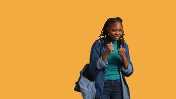 African american woman jokingly pretending to fight, having friendly confrontation with friend. Young girl mock boxing with mate, holding combat stance, studio background, camera B video