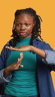 Vertical Portrait of assertive woman asking for timeout, doing hand gestures, feeling fatigued. Unhappy girl doing vehement pause sign gesturing, wishing for break, studio background, camera A video