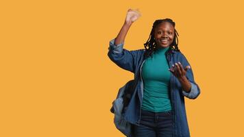 Enthusiastic african american student raising hand up to answer question, excited to tell teacher explanation to question in class, isolated over studio background, camera B video