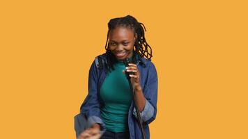 Portrait of african american motivational speaker talking in microphone, addressing audience, isolated over studio background. Expressive lecturer using mic, inspiring motivation, camera A video