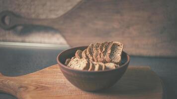 Baked rye crackers in a clay plate on a wooden board photo