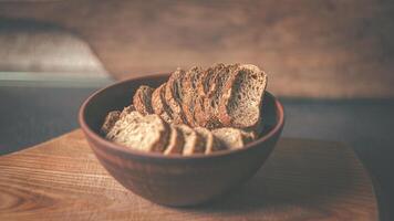Rye crackers in a clay plate on a wooden board photo