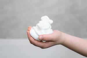 Shaving foam on a boy's hand in the bathroom close up photo